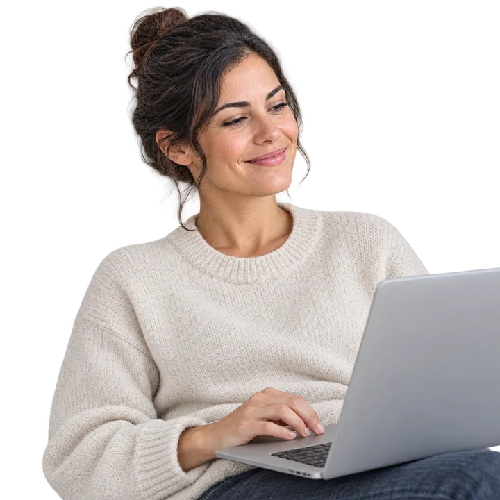 The same business owner, relaxed and smiling at a laptop